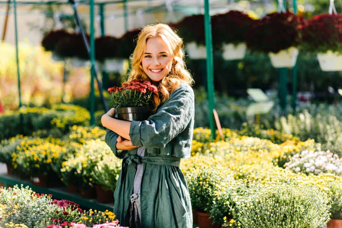 woman hugging a potted plant in a greenhouse